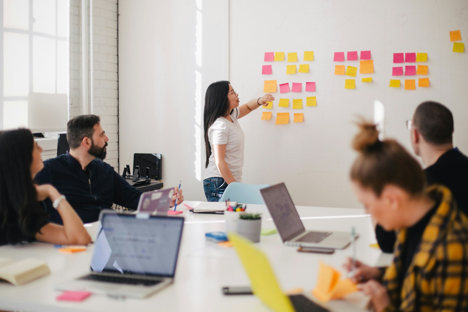 A team mapping out a project with sticky notes on a glass wall