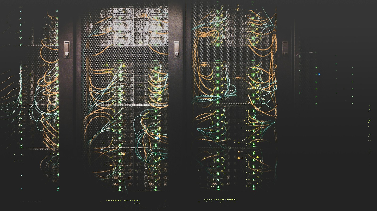 Rows of network cabling and lit servers in a data centre rack
