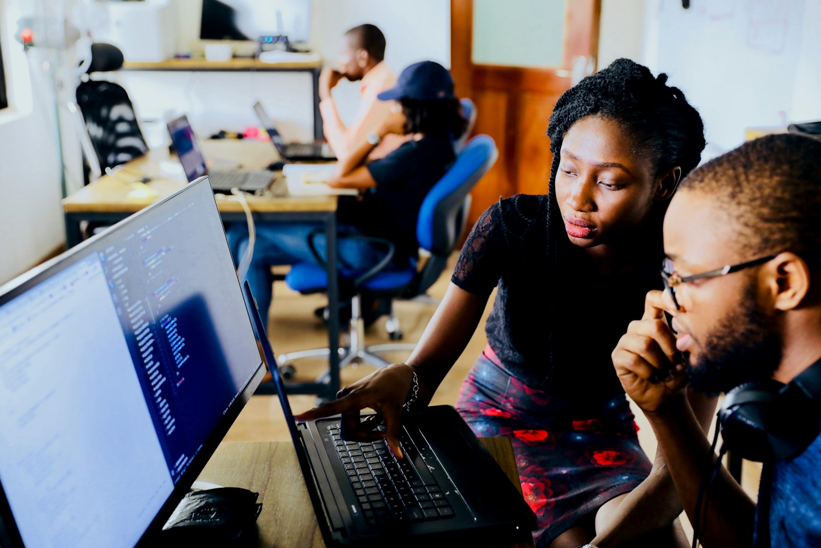 Two engineers working through code together at a laptop