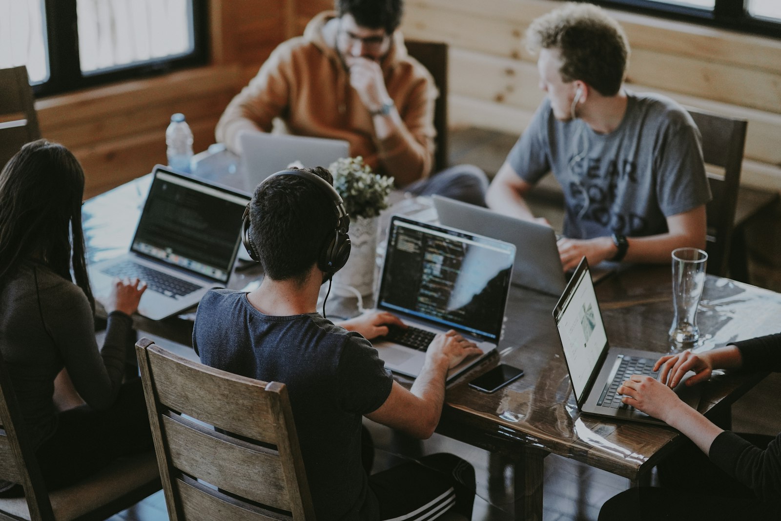 A team working side by side on laptops around a shared table